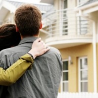 couple in  front of one-family house in modern residential area